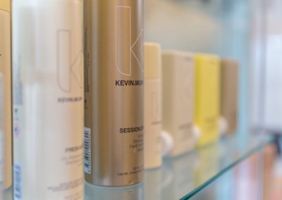 Assortment of Kevin Murphy hair products, including shampoos, conditioners, and styling products with sleek packaging and labels showcasing the brand's commitment to quality and style.